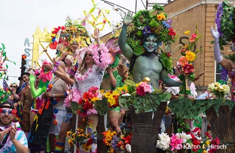 Painted person with head dress of flowers in colorful float